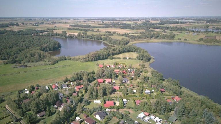Fotografia lotnicza przedstawiająca jezioro Mórka oraz jezioro Cichowo. Widać liczne drzewa oraz zabudowania.