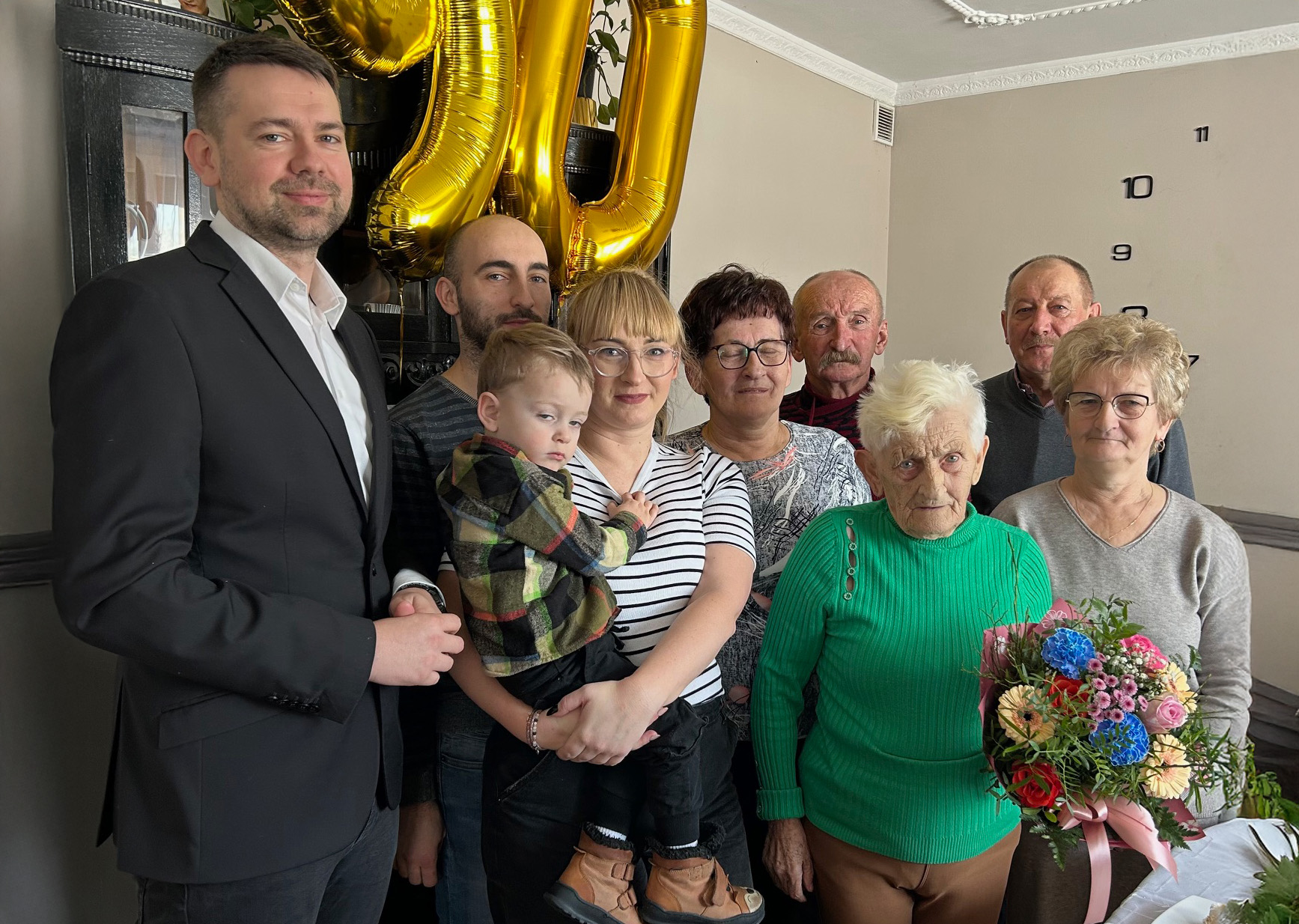 Zdjęcie przedstawiające grupę osób otaczających osobę świętującą urodziny.