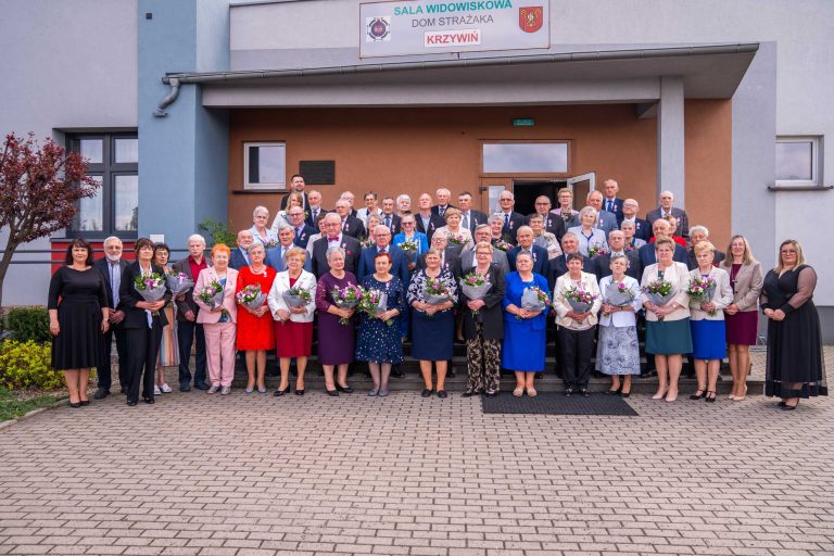 Fotografia przedstawiająca grono starszych osób świętujących jubileusz 30-lecia wspólnego życia wraz z oficjalnymi gośćmi wydarzenia. Charakter formalny.